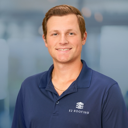 Cayden Frankie, Sales Associate at E2 Roofing, wearing a branded polo shirt, smiling against a blurred office background, representing the company's commitment to community and service in Jacksonville, Florida.