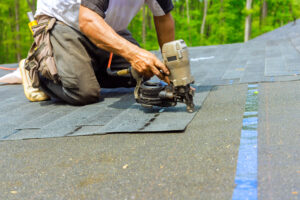 Roofer installing shingles with nail gun, Jacksonville roofing maintenance and repair.