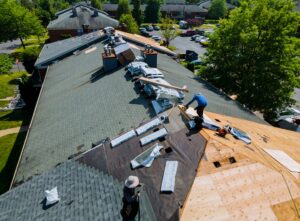 Workers replacing asphalt shingles on a multi-family apartment roof in Jacksonville, FL, showcasing roofing maintenance